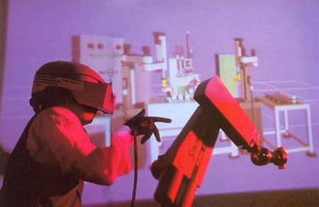 Цех виртуальной фабрики, где человек в электронном шлеме и перчатках управляет виртуальным роботом-манипулятором.